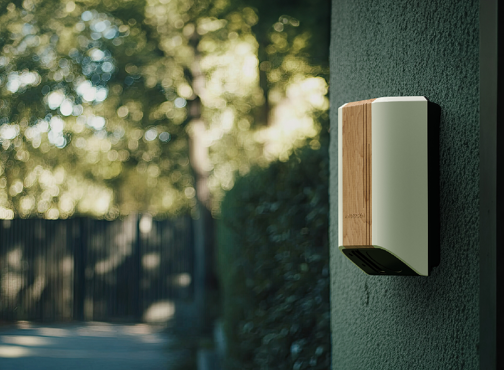 Andersen Quartz EV charger installed outdoors on brick wall beside parked electric car